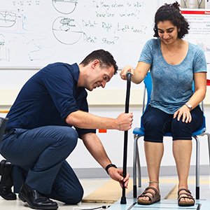 Physical Therapist helping a woman with cane
